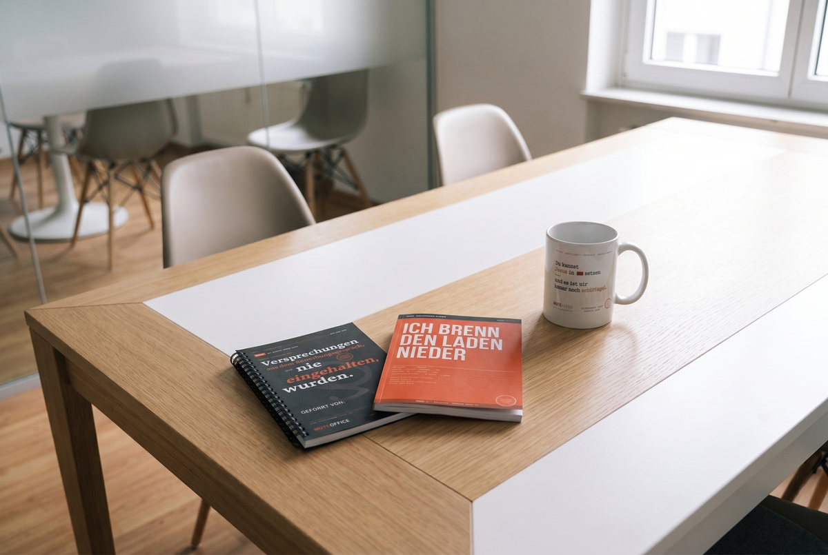 MUTE OFFICE Set – Büro-Überlebenspaket – Jesus-im-CC-Tasse, Notizbuch und Malbuch im Meetingraum